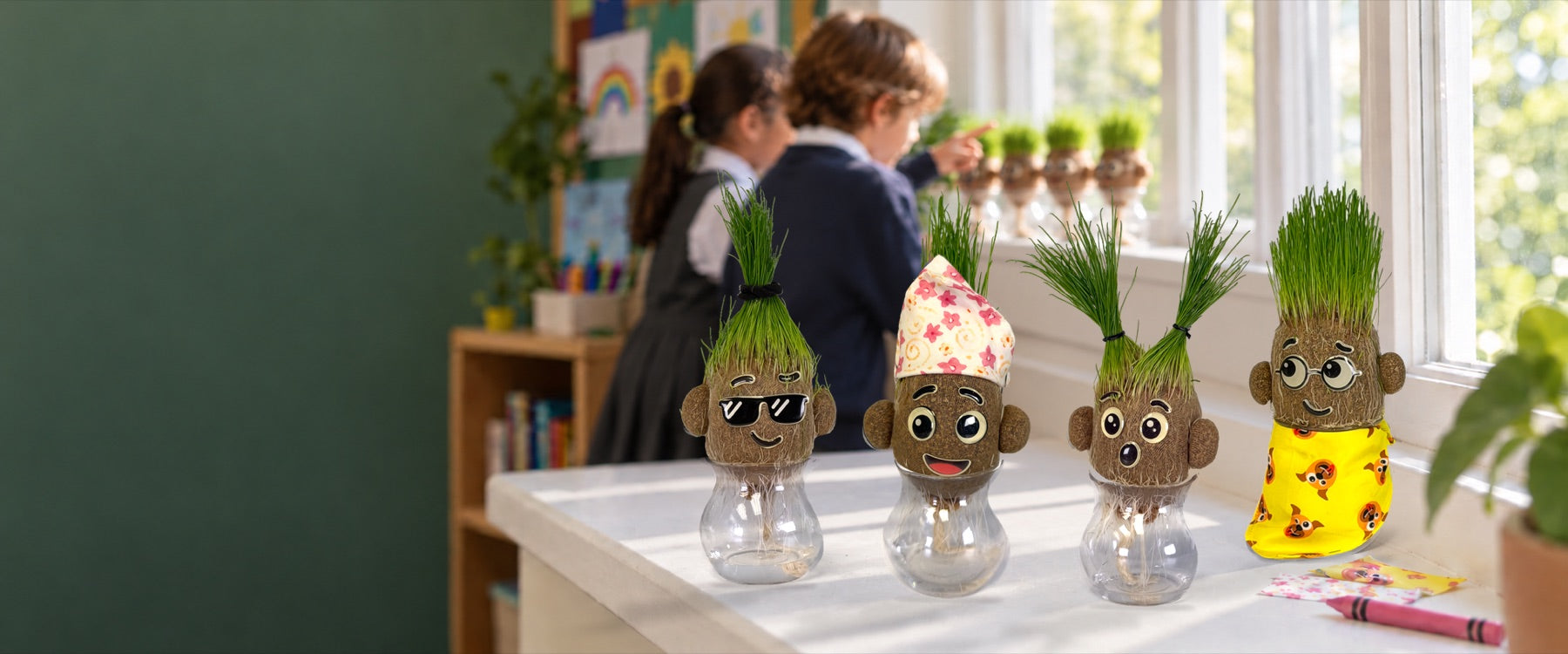 Four grown Growbies with different haircuts on a sunny classroom windowsill, two students behind